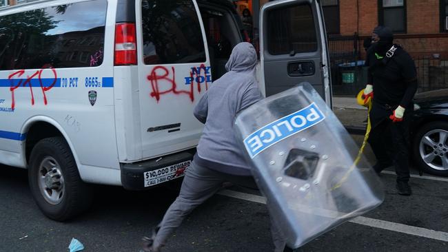 A man attacks an NYPD police van and smashes its windows. Picture: AFP