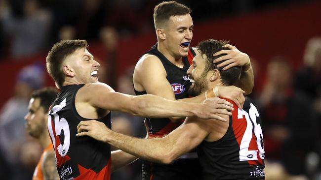 Cale Hooker celebrates his matchwinning goal with Orazio Fantasia and Jayden Laverde. Picture: Dylan Burns/AFL Photos.