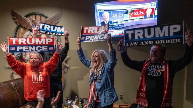 Supporters of US President Donald Trump celebrate as they watch Ohio being called for Donald Trump at a Republican watch party at Huron Vally Guns in New Hudson, Michigan, November 3, 2020. - President Donald Trump and Democratic challenger Joe Biden are battling it out for the White House, with polls closed across the United States Tuesday -- and a long night of waiting for results in key battlegrounds on the cards. (Photo by SETH HERALD / AFP)