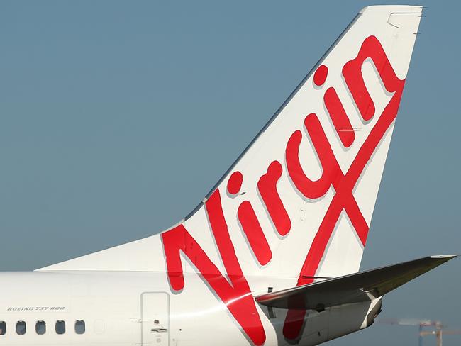 The Virgin Australia Holdings Ltd. logo is displayed on the tails of a Boeing Co. 737-800, left, and a Boeing Co. 737-8FE aircraft preparing to take off at Sydney Airport in Sydney, Australia, on Monday, Feb. 8, 2016. Virgin Australia is scheduled to announce half-year earnings on Feb. 11. Photographer: Brendon Thorne/Bloomberg