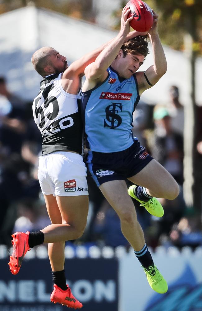 Joshua Hone of Sturt marks in front of Josh Simpson of the Magpies.