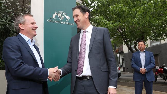 New Cricket Australia CEO Kevin Roberts, left, shakes hands with his predecessor James Sutherland as Mr Peever looks on. Picture: David Crosling