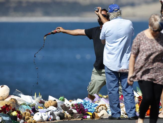 Friends and family at the wharf where Damien Little and his children died.