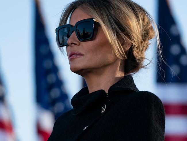 (FILES) In this file photo outgoing First Lady Melania Trump listens as her husband Outgoing US President Donald Trump addresses guests at Joint Base Andrews in Maryland on January 20, 2021. - The backdrop of flowers, teapot and US flag said it all: Jill Biden will be no Melania Trump as America's new first lady. Where Donald Trump's ex-model wife cut a flashy but often distant figure, Jill Biden's appearance on a Zoom "virtual tea" party February 3 with military spouses affirmed her image as a down-to-earth, traditional FLOTUS. (Photo by ALEX EDELMAN / AFP)