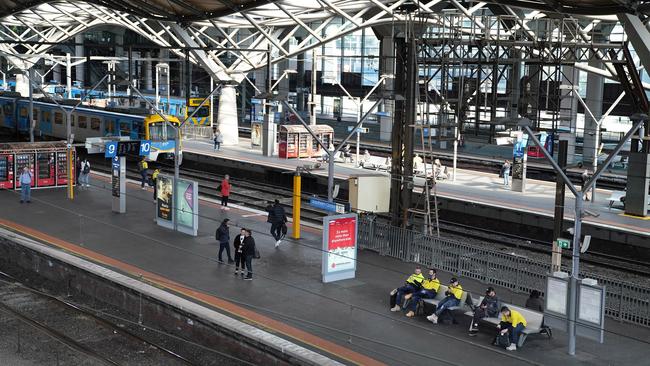 Commuters are seen at Southern Cross Station in Melbourne, Tuesday, March 24, 2020. A shutdown of non-essential services is in effect Australia wide in a bid to slow the spread of the coronavirus (COVID-19) disease. (AAP Image/Stefan Postles)