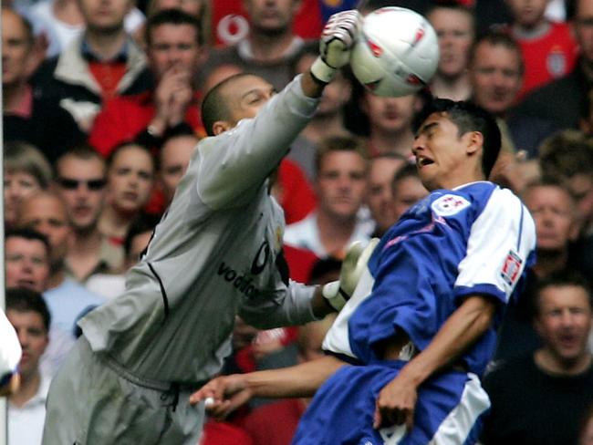 Manchester United goalkeeper Tim Howard gets to the ball just ahead of Milwall’s Tim Cahill during the 2004 FA Cup final. Picture: AFP