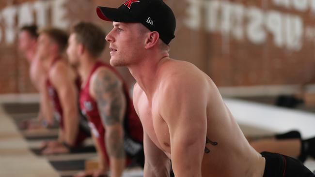 Newnes and his teammates complete some yoga in the heat. Picture: Alex Coppel