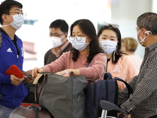 Travellers aren’t taking any risks as they arrived in Sydney from Shanghai on Saturday, wearing masks around the airport and beyond. Picture: Chris Pavlich