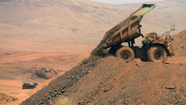 An autonomous haul truck dumps a load of rock in the mine pit at Rio Tinto Group's Gudai-Darri iron ore mine in the Pilbara region of Western Australia, Australia, on Thursday, Oct. 19, 2023. Rio Tinto is preparing for trials of battery-powered locomotives in Australia, where it uses giant autonomous trains — the world’s largest and longest robots — to transport iron ore across the vast Outback. Photographer: Carla Gottgens/Bloomberg