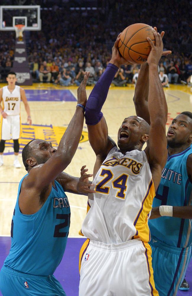 Los Angeles Lakers guard Kobe Bryant, center, puts up a shot as Charlotte Hornets center Al Jefferson, left, and forward Michael Kidd-Gilchrist defend.