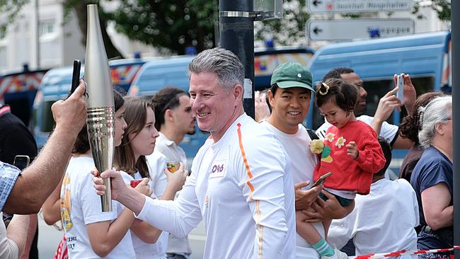 Nine boss Mike Sneesby carries the Paris Olympics torch in the Olympic torch relay. Picture: Jacquelin Magnay