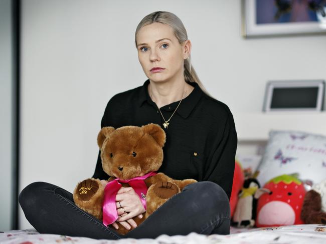 Kelly O’Brien sitting on her late daughter Charlotte’s bed, holding ‘Charlie Bear’ which houses her late Charlotte’s ashes. Picture: Sam Ruttyn