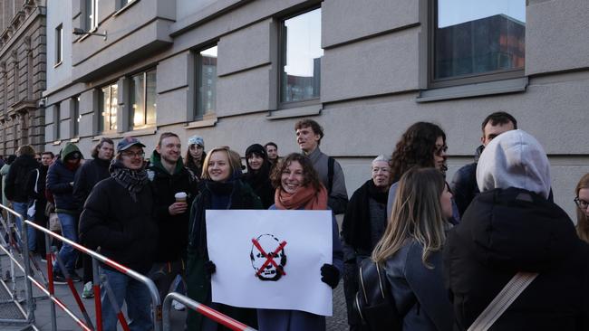 Expatriate Russian citizens, including a young group with an anti-Vladimir Putin placard, wait to vote at the Russian Embassy. Picture: Getty Images.