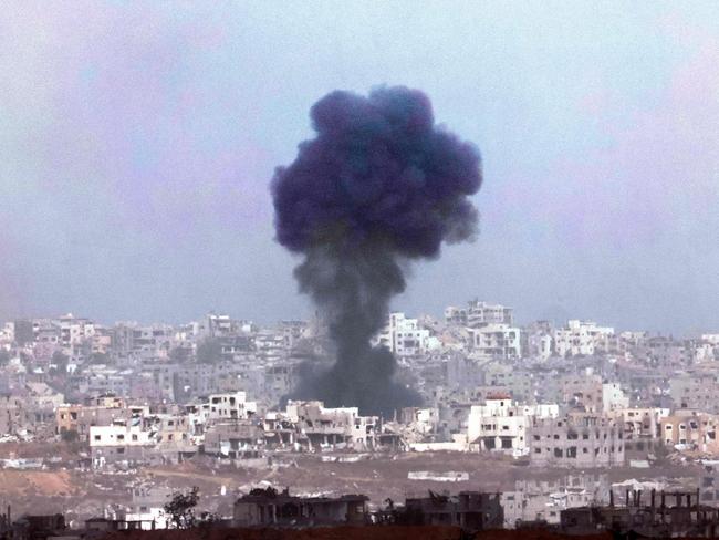 Smoke billows above destroyed buildings in Gaza this week. Picture: Getty