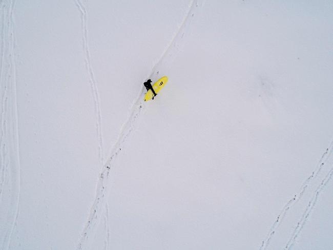 A surfer carries his surfboard as he walks through the snow out of the water on March 11, 2018 in Unstad, northern Norway, Lofoten islands, within the Arctic Circle as air temperature drops minus 13°C and water temperature above 4°C. Picture: AFP