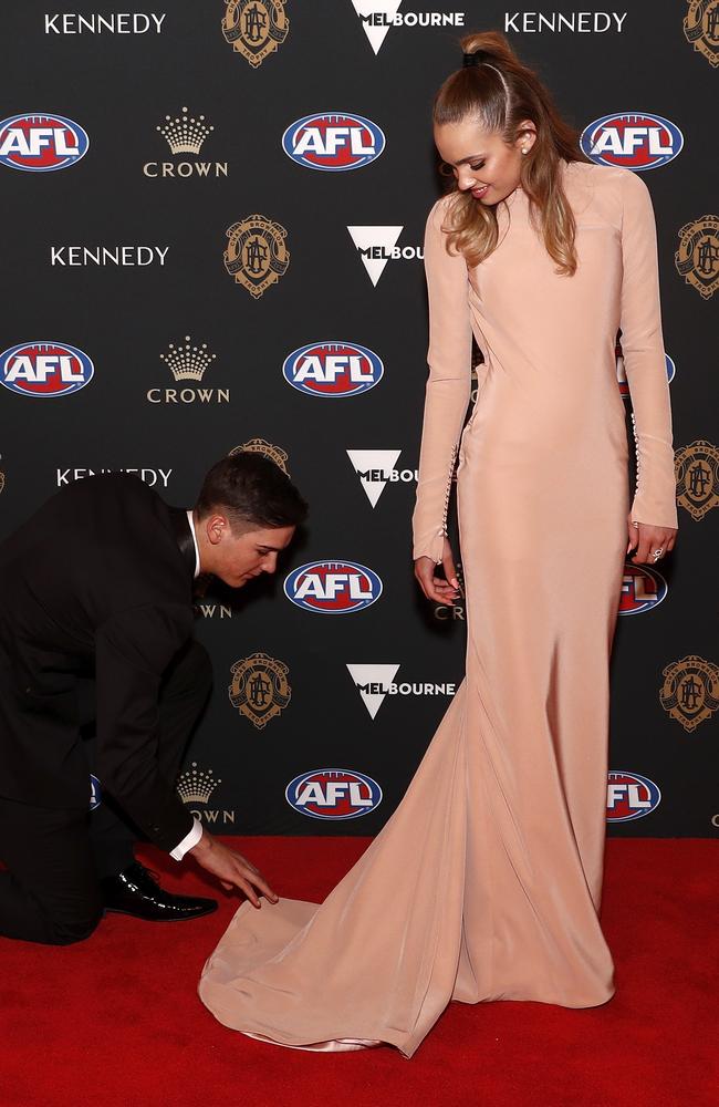 Connor Rozee helps partner Sophie Barbour with her train on the red carpet. Picture: Daniel Pockett/AFL Photos