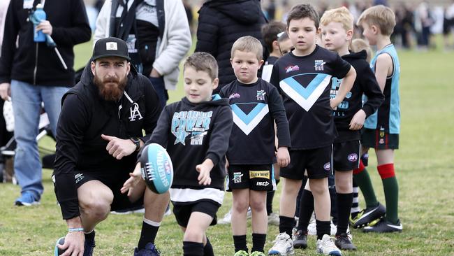 Charlie Dixon helps kids with their goal kicking at Port Adelaide’s Super Football Clinic at Alberton oval. Picture SARAH REED