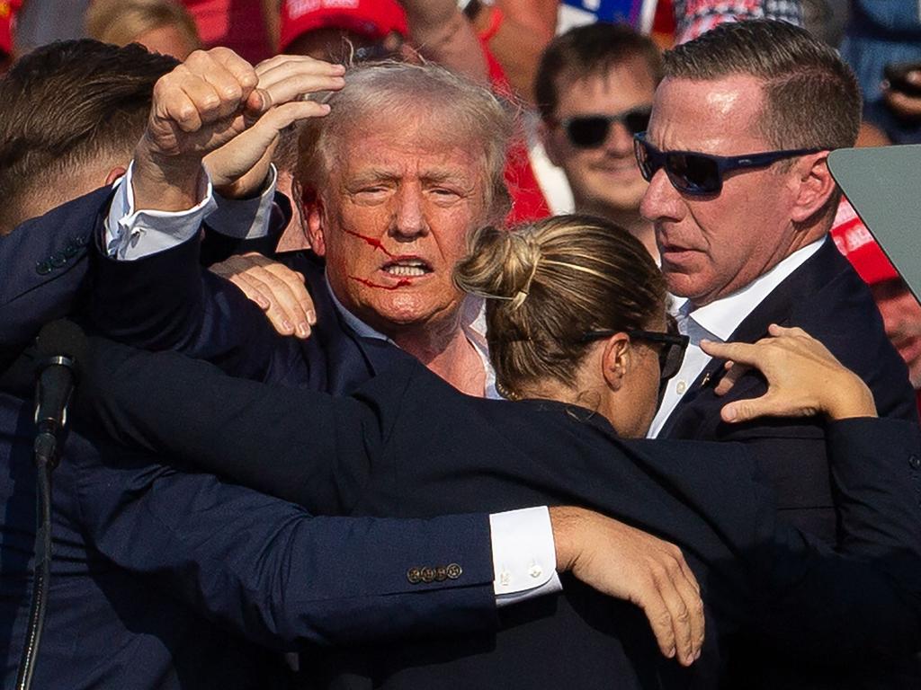 The image of wounded US Republican candidate Donald Trump surrounded by secret service agents after the assassination attempt was beamed across the world and inspired Mark Knight’s cartoon. Picture: Rebecca Droke/AFP