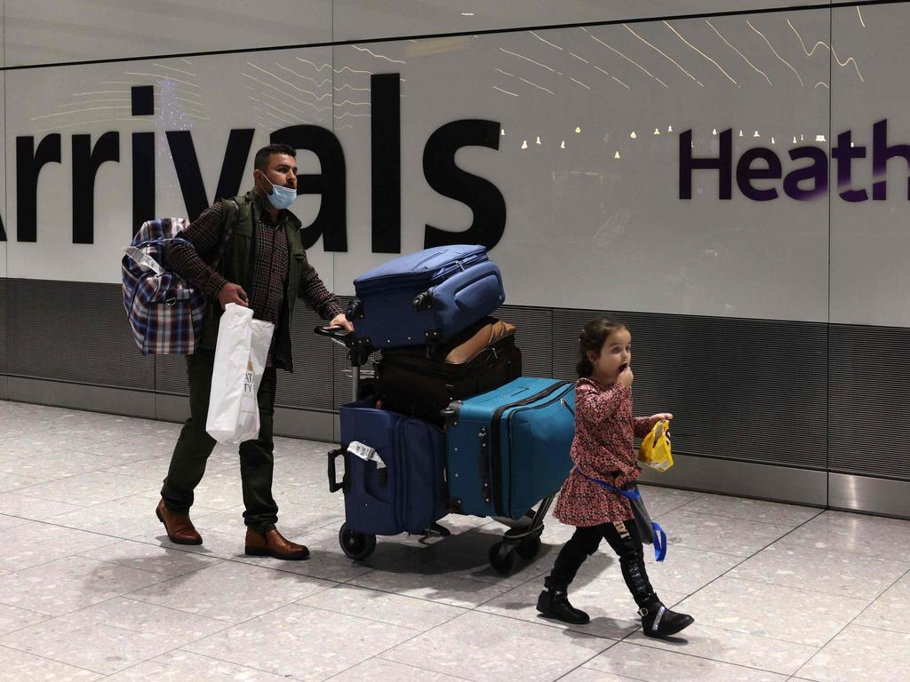 People arrive at Heathrow's Terminal 5 in west London on November 30, 2021 as new restrictions on travellers are introduced. - All passengers entering the UK are advised from Tuesday to take a PCR test for Covid-19 two days after their arrival, and to self-isolate until the receive a negative result. (Photo by Adrian DENNIS / AFP)