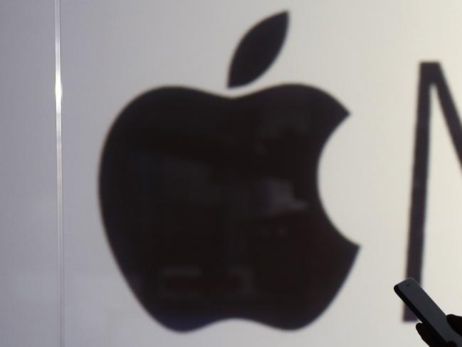 A man dances to music being streamed on his Apple Inc. iPhone 6s whilst framed against a wall bearing the Apple music symbol in this arranged photograph in London, U.K., on Wednesday, Dec. 23, 2015. Beatles songs will now be available around the world on nine streaming services including Apple, Spotify, Deezer and Google Play, the bands record company, Vivendi SAs Universal Music Group, said Wednesday in a statement. Photographer: Chris Ratcliffe/Bloomberg