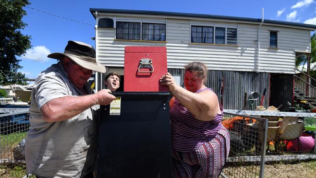 Toni Hay (right) is helped by friends as she moves items to safety before expected flooding in Rockhampton. Picture: AAP Image/Dan Peled