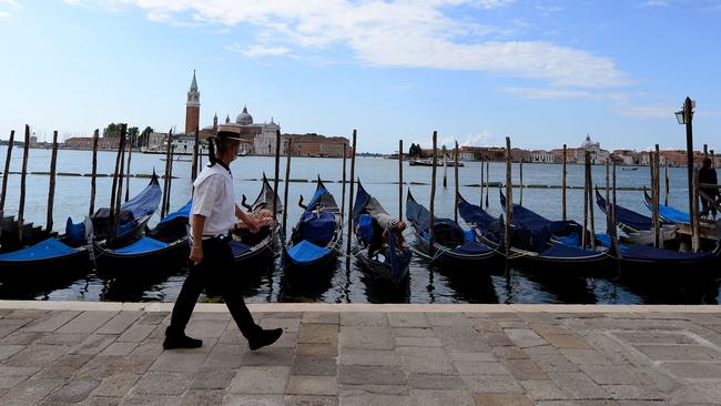 A gondoliers walks past a row of boats in Venice. Picture: AFP