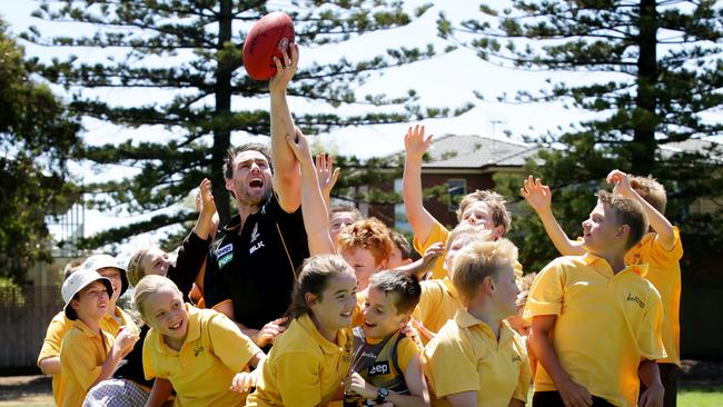 Former Richmond captain Chris Newman has a bit of fun with students from Warrnambool Primary school. Picture: Colleen Petch.