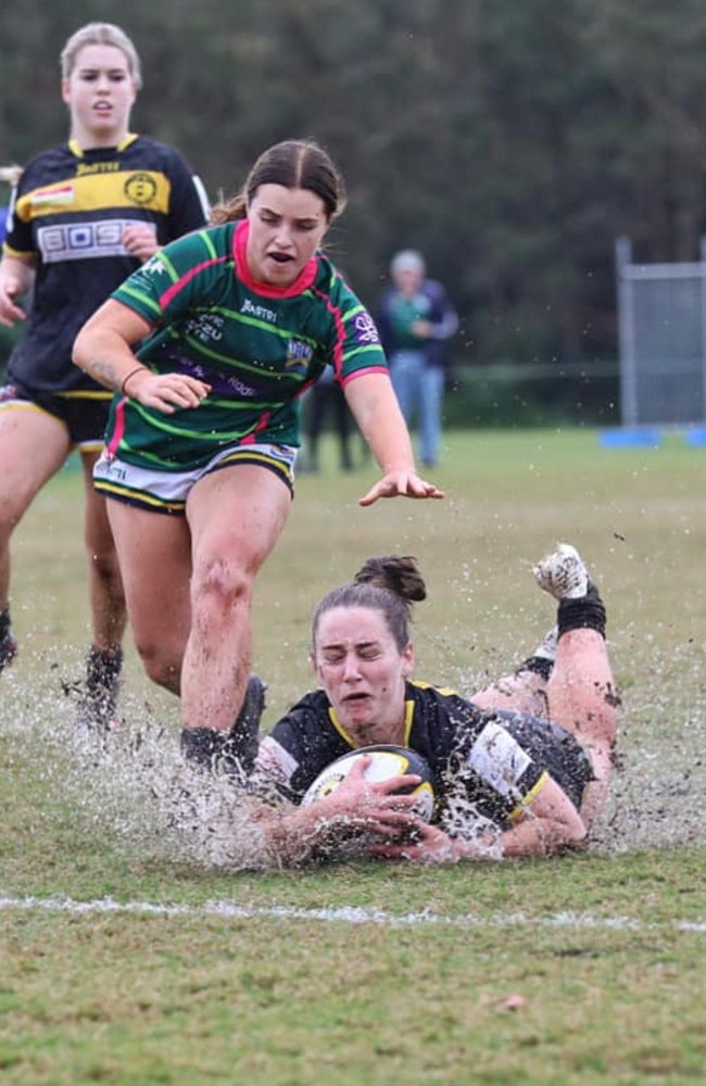 Taylor Aldridge dives over in wet and muddy conditions for her Caloundra Lighthouse team.