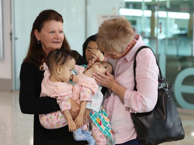 Kilmore's Children First Foundation Miracle Smiles Retreat volunteer Sharyn Hood and Retreat Manager Debbie Pickering hold Nima and Dawa, as they arrive into Melbourne. Picture: Alex Coppel