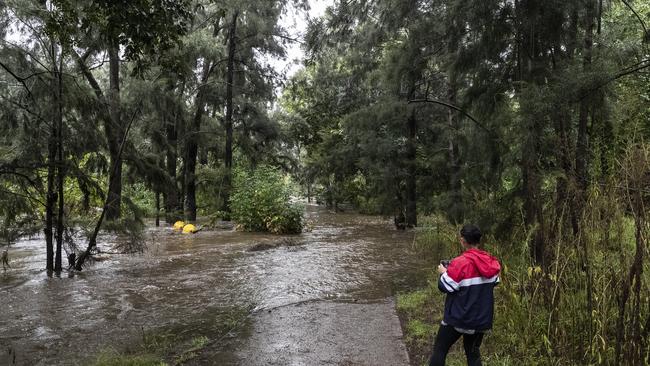 A person is seen next to the overflowing Nepean River at the Penrith weir on March 20. Picture: Brook Mitchell/Getty Images