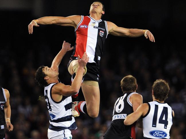 Michael Gardiner flies over Cats ruckman Shane Mumford early in the 2009 clash.