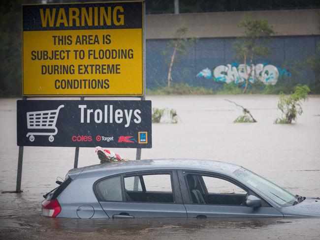 Submerged cars sit in a flooded carpark in Toombul, Queensland. Picture: AFP/Patrick Hamilton