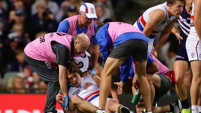 Liam Picken is helped by Western Bulldogs trainers after being knocked out against Fremantle. Picture: Getty