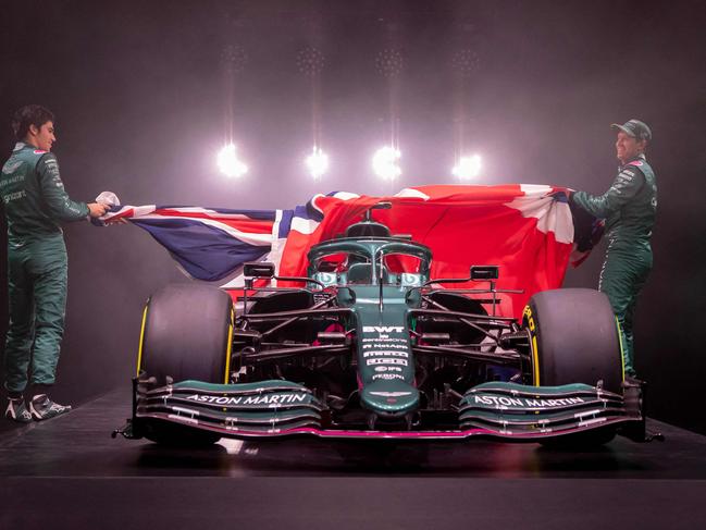 A handout photograph released by Aston Martin Cognizant Formula One Team on March 3, 2021 shows the team's AMR21, their new car for the 2021 Formula One season, being unveiled by drivers Sebastian Vettel (R) and Lance Stroll (L) during a virtual launch event at their headquarters in Gaydon, central England. (Photo by - / ASTON MARTIN / AFP) / RESTRICTED TO EDITORIAL USE - MANDATORY CREDIT 