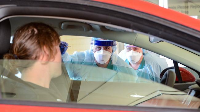 Nurses test a patient at the drive-through coronavirus testing clinic at the Repat Hospital, Daw Park.