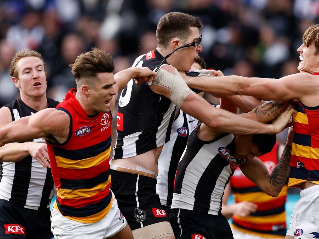 Ben Keays of the Crows removes the glasses of Mason Cox of the Magpies during round 15.