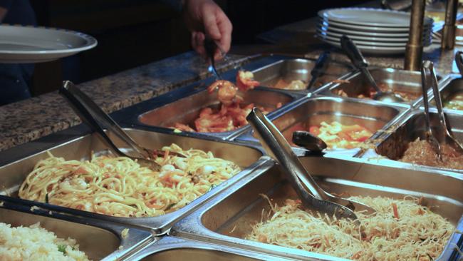 steel trays with food in the canteen of the self-service restaurant. Chinese smorgasbord