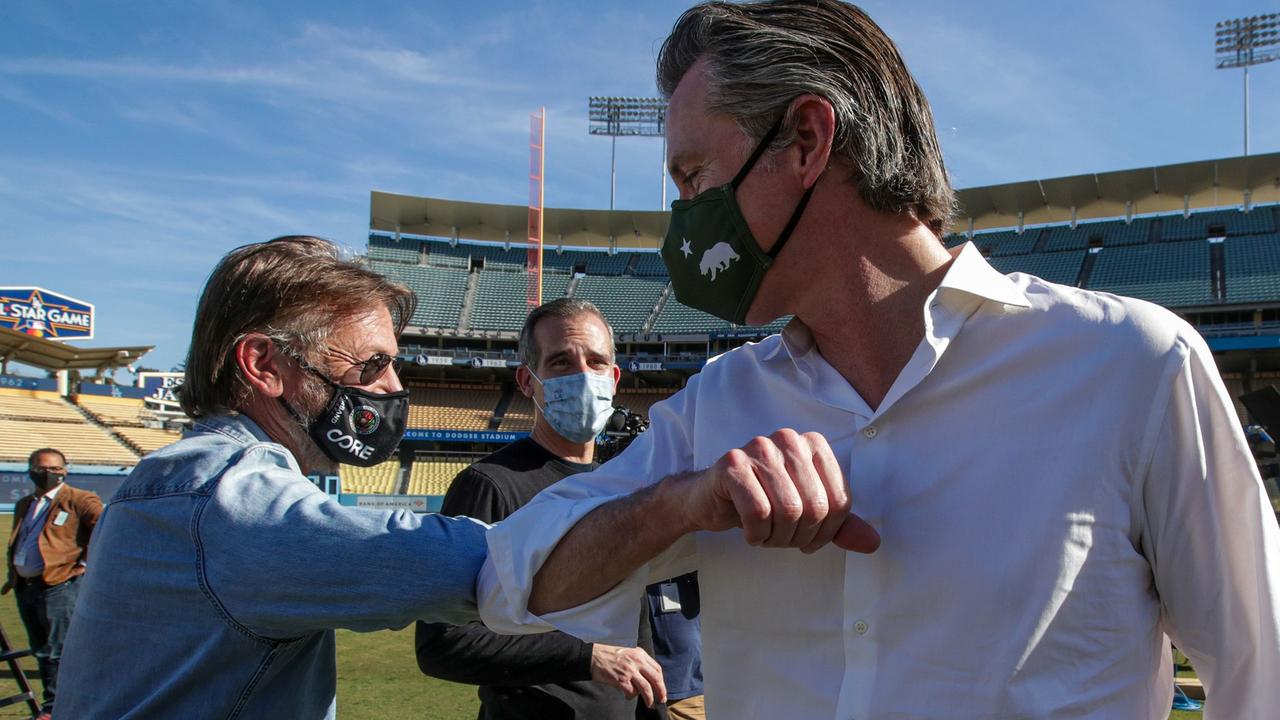 Sean Penn (L), Los Angeles Mayor Eric Garcetti (C) and California Governor Gavin Newsom greet each other at the launch of a mass COVID-19 vaccination site at Dodger Stadium on January 15, 2021 in LA. Picture: AFP