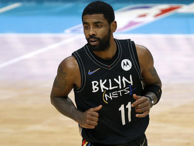 (FILES) In this file photo Kyrie Irving #11 of the Brooklyn Nets runs the court during the fourth quarter of their game against the Charlotte Hornets at Spectrum Center on December 27, 2020 in Charlotte, North Carolina. - The NBA said on September 29, 2021 players who do not comply with local Covid-19 vaccination mandates will be docked pay for games they are forced to miss because of their status. The policy means players with teams based in San Francisco and New York -- where local regulations require full vaccination for indoor events -- must get vaccinated or else risk seeing their pay effectively cut in half. (Photo by Jared C. Tilton / GETTY IMAGES NORTH AMERICA / AFP)
