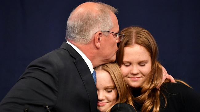 Prime Minister Scott Morrison gives a hug to his daughters Lily and Abbey following his defeat.