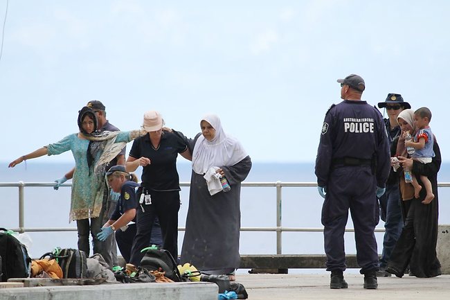 Women and children were among those brought ashore and checked by federal Customs staff. Picture: Kent Retallick