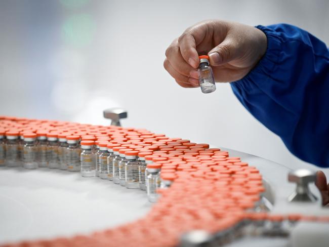 A staff member works during a media tour of a new factory built to produce a COVID-19 coronavirus vaccine at Sinovac, one of 11 Chinese companies approved to carry out clinical trials of potential coronavirus vaccines, in Beijing on September 24, 2020. (Photo by WANG ZHAO / AFP)