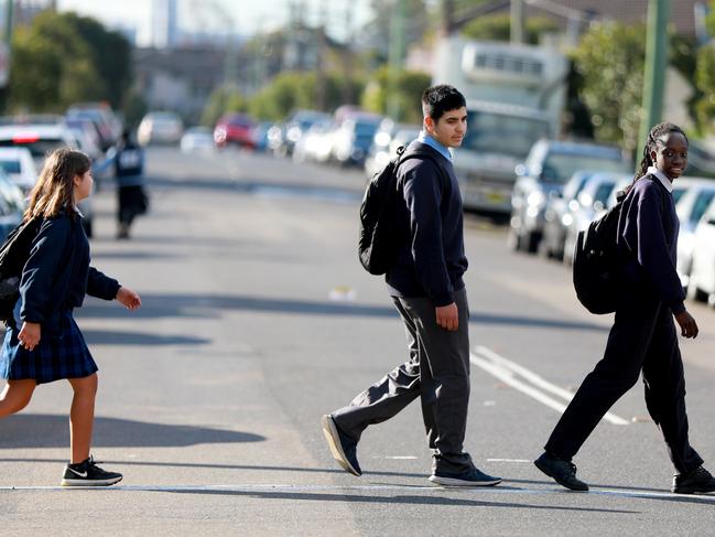 PARRAMATTA ADVERTISER/AAP. Granville South Creative and Performing Arts High School students Aisha El-maroukv 13, Maher Haouchar 16 and Sandra Kakari cross Excelsior St in Guildford. Guildford, Friday 28 June, 2019. The school has signed a petition presented to Cumberland Council calling for a pedestrian crossing and hump at the south side of Excelsior St. (AAP IMAGE / Angelo Velardo)