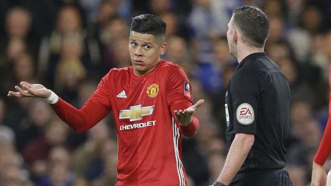 Manchester United's Marcos Rojo, left, gestures to referee Michael Oliver.