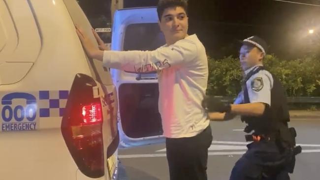 Human rights activist Drew Pavlou being arrested in Sydney after holding a "Down with Xi Jinping" sign. He was held in custody for five hours. Picture: Twitter