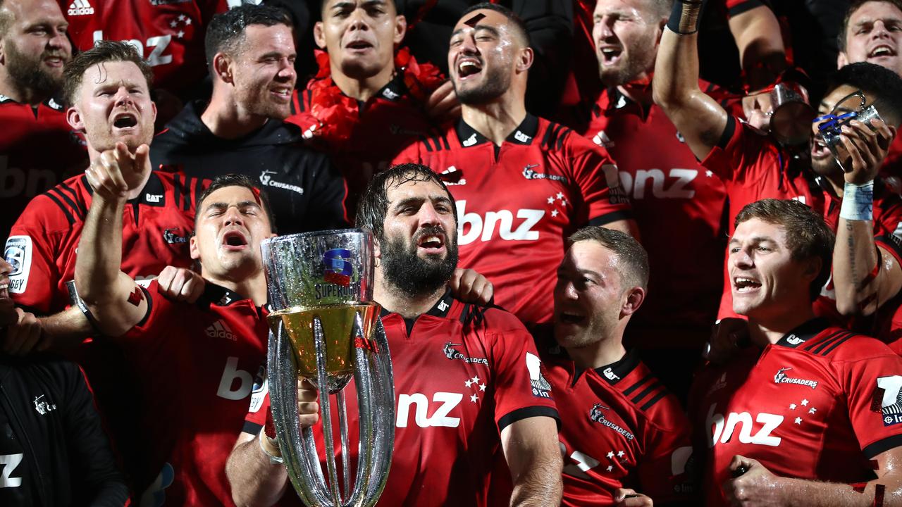 Sam Whitelock of the Crusaders and teammates pose with the Super Rugby trophy.