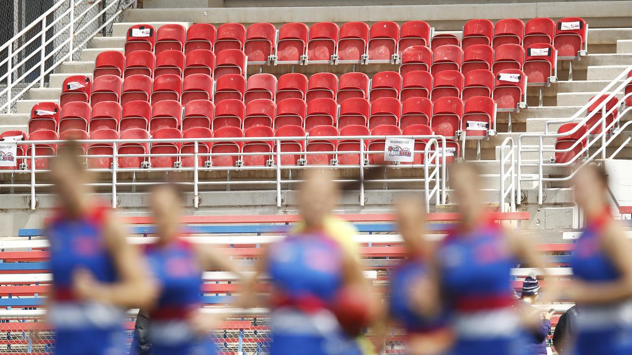 Bulldogs players warm up in front of empty stands prior to an AFLW game on Sunday.