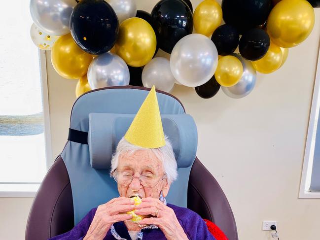 Karinity Carinya aged care resident Mavis Cumner enjoys some cake as part of her 100th birthday celebration.