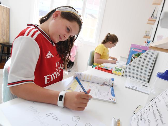 Audrey Merriman (left), 9, and her sister Grace, 8, are seen learning from home on the first day of Term 2 in Brisbane, Monday, April 20, 2020. Only the children of essential workers and students deemed vulnerable are expected at Queensland schools as part of the efforts to fight the COVID-19 pandemic. (AAP Image/Dan Peled) NO ARCHIVING