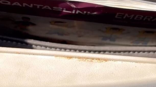 A tray table inside a Qantas link flight with crusty food. Photo: Tayla Couacaud